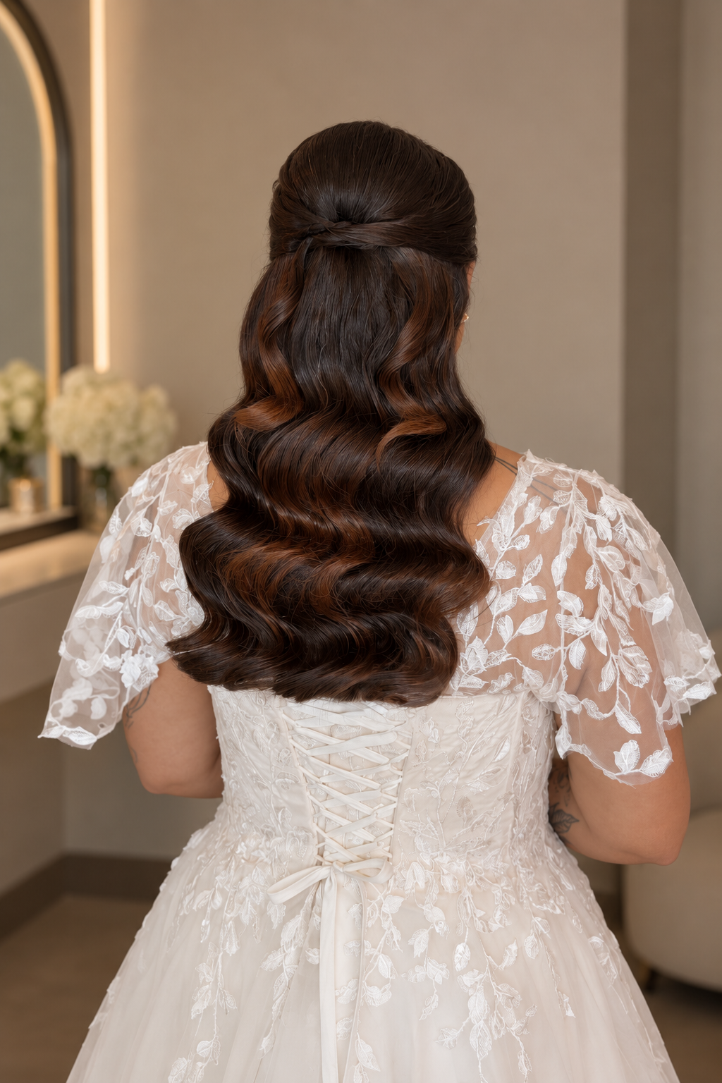 Bride from behind showing intricate bridal hairstyling and lace dress details